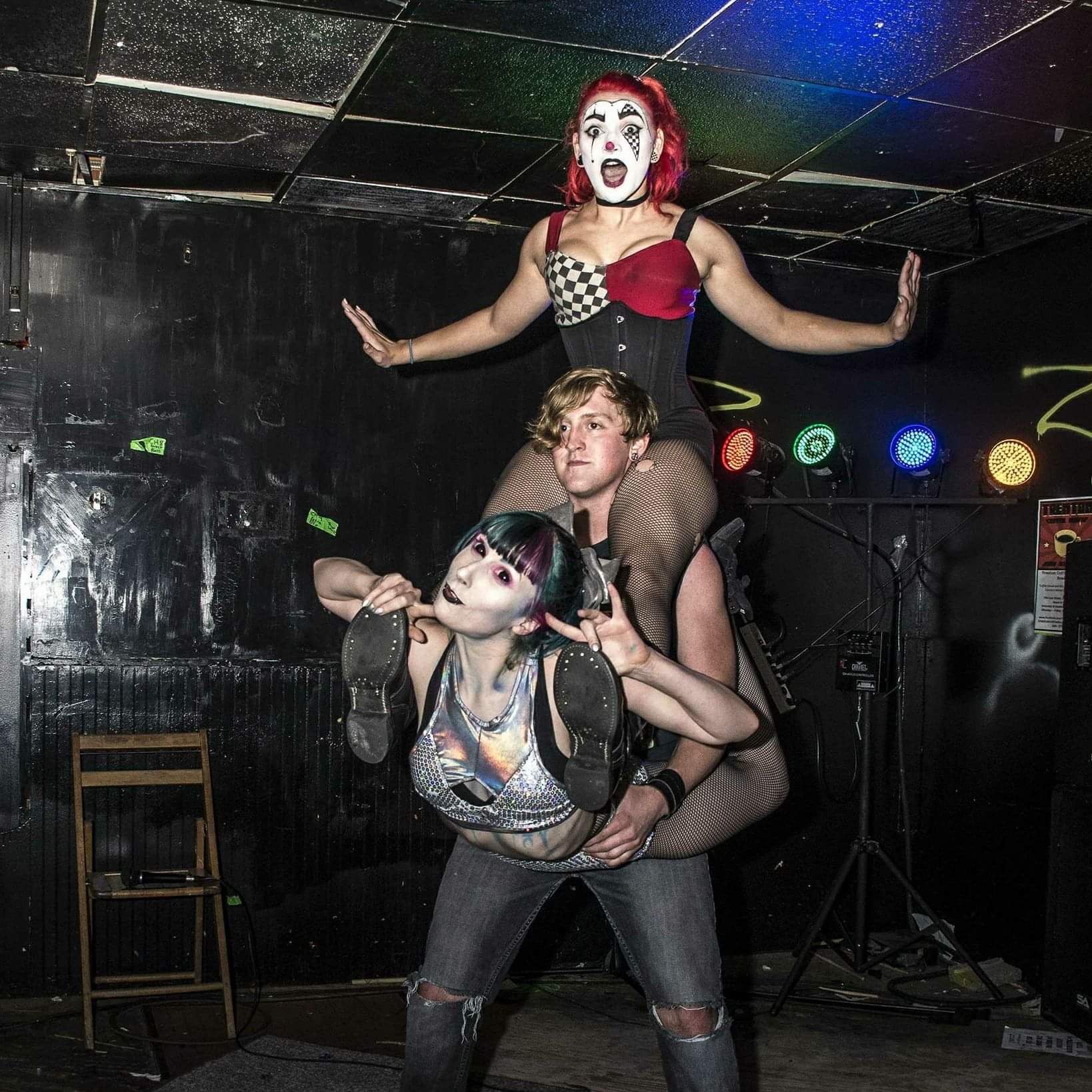 Reid Wilson strongman act holding two performers in human pyramid at nightlife circus show