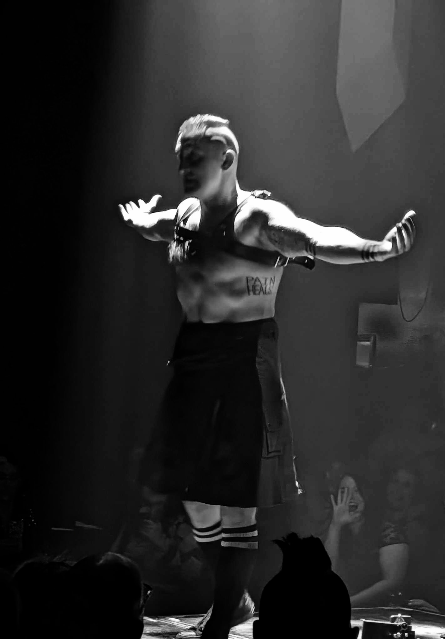 BF Reid performing live circus strongman act with dramatic stage lighting and audience