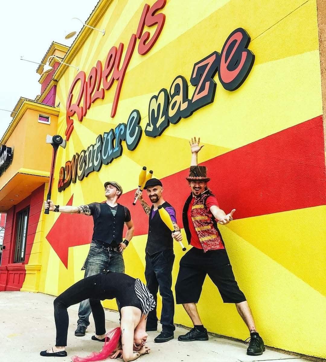 Reid Wilson and circus performers in colorful costumes outside Ripley's Adventure Maze building